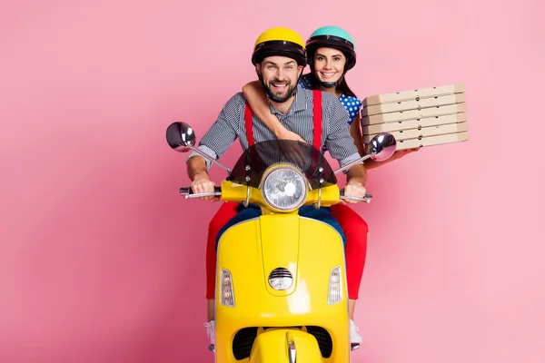 Retrato de su ella ella agradable atractiva alegre alegre pareja cuidadosa conducción ciclomotor llevando pasteles de pizza comida de aperitivo en casa cena aislada sobre fondo de color pastel rosa —  Fotos de Stock