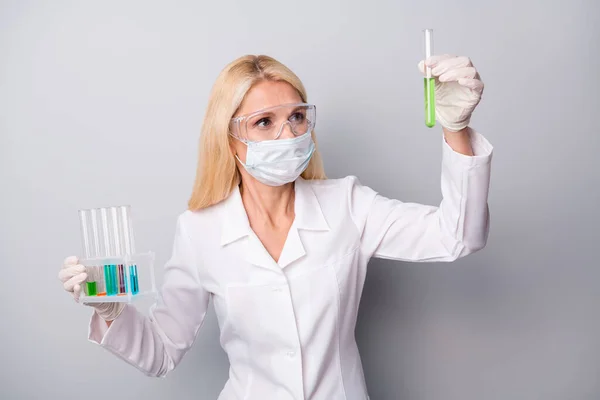 Retrato de cientista especialista focado aposentado aposentado mulher segurar frasco químico corona vírus pesquisa trabalho antídoto óculos de desgaste luvas de látex máscara isolado fundo cor cinza — Fotografia de Stock