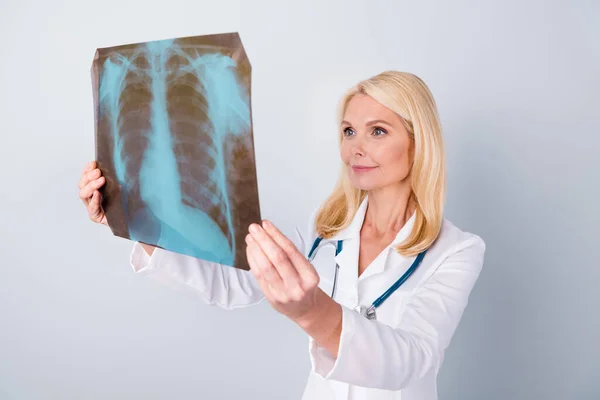 Photo of experienced retired pensioner woman oncologist hold x-ray photo analyze covid-19 patient lungs diagnosis bronchitis asthma have stethoscope isolated over gray color background — Stock Photo, Image