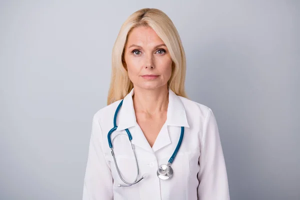Ciddi nitelikte yaşlı kadın yönetici doktorunun portresi. Enfeksiyon yaymayı bırakın. Gri arka planda izole edilmiş beyaz önlük giyin. — Stok fotoğraf