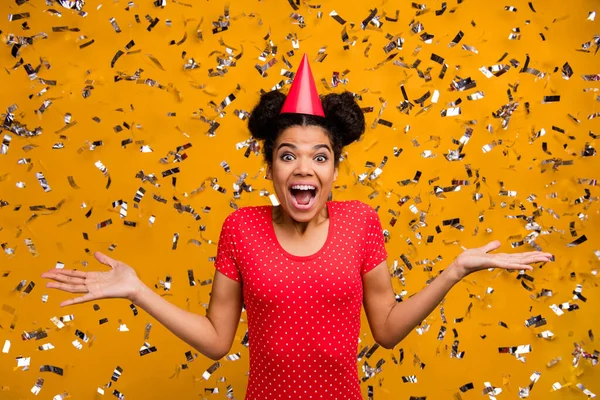 Portrét vzrušený překvapený afro americká dívka slavit funky pozitivní příležitost zapůsobil konfety pádu létání oblečení červené tečkované tričko izolované přes jasný lesk barvy pozadí — Stock fotografie