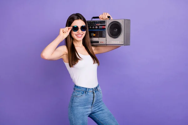 Retrato de chica joven alegre positiva disfrutar escuchar música retro sostener hombros boom box usar gafas de sol buen traje de aspecto aislado sobre fondo de color vívido — Foto de Stock