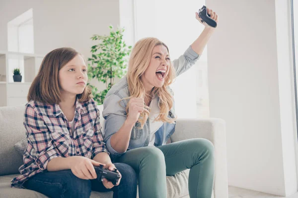 Foto van gek grappig blond dame schreeuwen moeder dochter zitten sofa hold joystick spelen video game winnaar verliezer thuis blijven quarantaine doorbrengen weekend samen beste vrienden woonkamer binnen — Stockfoto