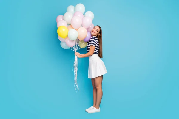 Ganzkörper-Profil-Foto der schönen hübschen Dame bringen viele bunte Luftballons Freund Geburtstagsparty Veranstaltung tragen gestreifte T-Shirt weißen kurzen Rock Schuhe isoliert blauen Farbhintergrund — Stockfoto