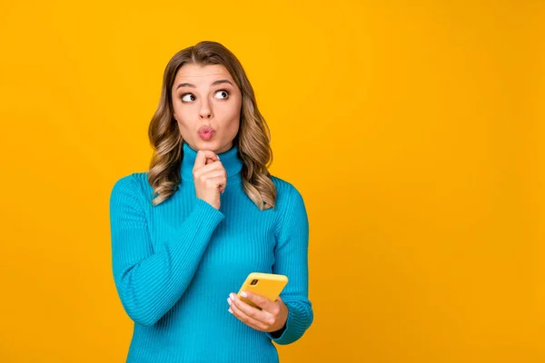 Foto de atractiva mujer ondulada blogger mantener el teléfono escribir nuevo post tema de la juventud buscar espacio vacío creativo enviar aire beso desgaste casual azul cuello alto aislado color amarillo fondo —  Fotos de Stock