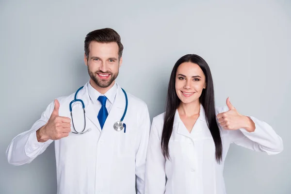 Foto von schönen Doc Kerl Dame zwei Menschen Notfall Patient Beratung Virologie Klinik Daumen hoch genehmigen Gesundheitszustand erfahrene Ärzte tragen Labormäntel isoliert graue Farbe Hintergrund — Stockfoto