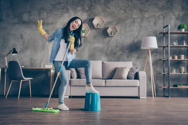 Volledige lengte lichaam grootte uitzicht van haar ze mooi aantrekkelijk mooi vrolijk vrolijk funky blij meisje doen opruimen opruimen met plezier zingen lied hit in moderne loft industrieel huis appartement — Stockfoto