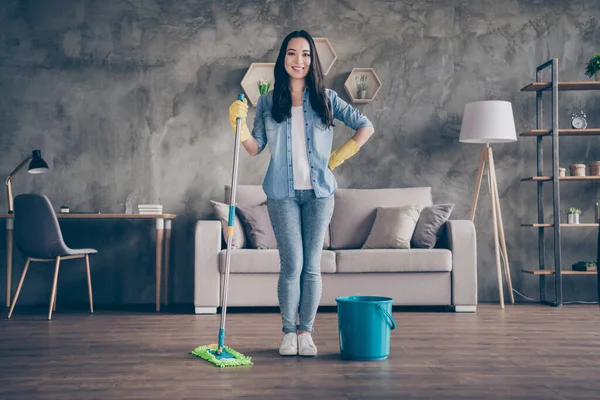 Comprimento total foto de doméstica bonita asiática senhora de pé auto-confiante sala de estar terminou limpeza geral ficar em casa quarentena limpo casa arrumado mente saúde empregada doméstica dentro de casa — Fotografia de Stock