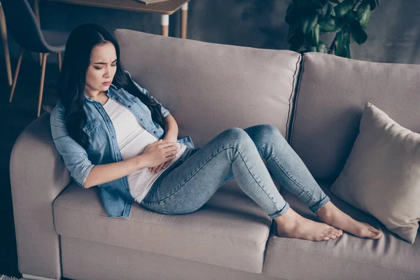 Nahoře nad vysokým úhlem pohledu fotografie frustrované nemocné dívky trpí pms příznaky dotek břicho ruka pláč ležel divan bosý oblečení denim v domě uvnitř — Stock fotografie