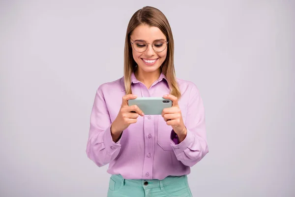 Porträtt av positiva glada flicka använda mobiltelefon sökning sociala medier information nyhet njuta kylning bära bra utseende kläder isolerade över grå färg bakgrund — Stockfoto