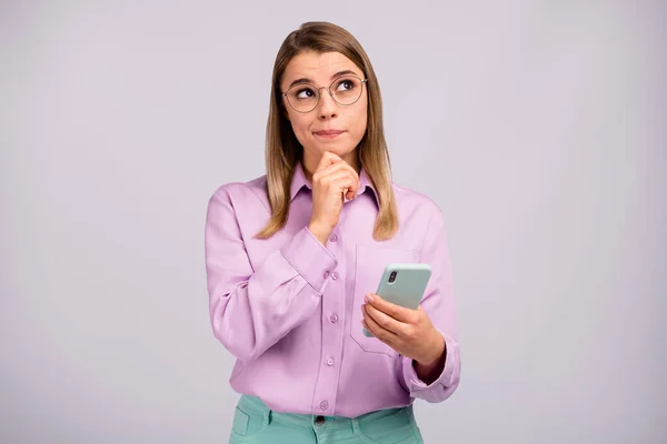 Портрет заинтересованной девушки smm использовать сотовый телефон взгляд copyspace думать, что мысли не могут выбрать хотите тип в блоге носить стильный фиолетовый цвет фона — стоковое фото