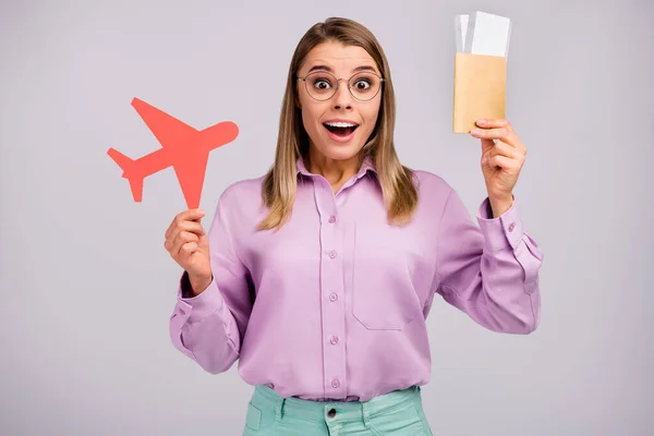 Retrato de surpreendido louco menina impressionado turismo ganhar loteria segurar vermelho papel cartão avião visto gritar wow omg desgaste elegante roupa isolada sobre fundo de cor cinza — Fotografia de Stock