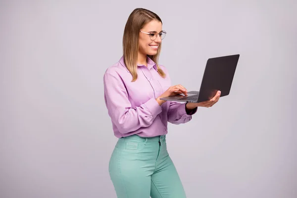 Retrato de confianza positiva gerente inteligente niña trabajo distancia uso portátil leer noticias de blogs sociales desgaste menta ropa violeta aislado sobre fondo de color gris — Foto de Stock