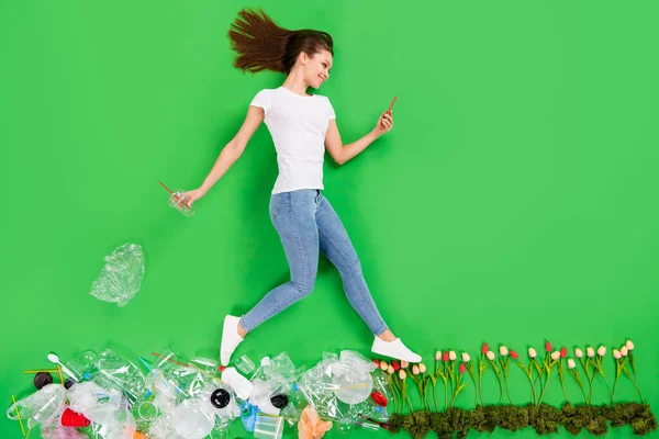 Full length high angle flat lay photo ανεύθυνη πολίτης κυρία ρίξει πλαστικά προϊόντα ρύπανση δρόμο βήμα φρέσκα λουλούδια τηλέφωνο εθισμένος απομονωμένο πράσινο χρώμα φόντο — Φωτογραφία Αρχείου