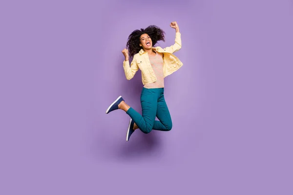 Longitud completa tamaño del cuerpo convertido en foto de alegre chica alegre saltando con evento victorioso en pantalones pantalones gritando color pastel aislado fondo violeta — Foto de Stock