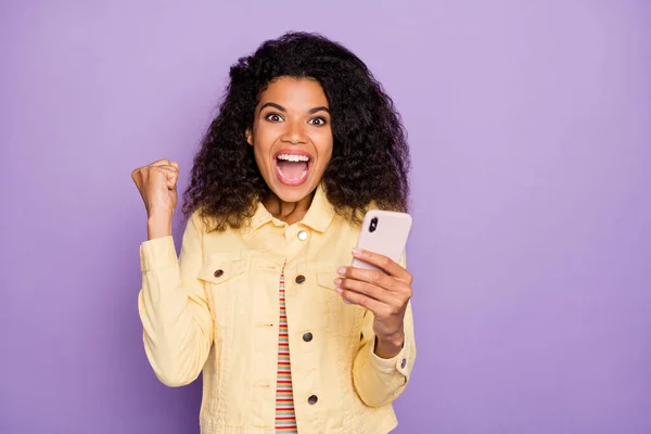 Foto de cabello castaño ondulado rizado excitado loca mujer alegre gritando sí moda gritando en chaqueta amarilla aislado pastel color fondo — Foto de Stock