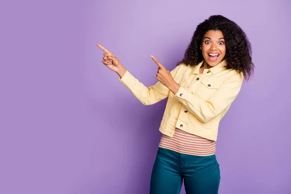 Портрет сумасшедший изумленный афро-американская девушка точка указательный палец копирайт промо советуем выбрать объявления кричать вау omg носить случайный стиль синие брюки изолированы на фиолетовый цвет фона — стоковое фото