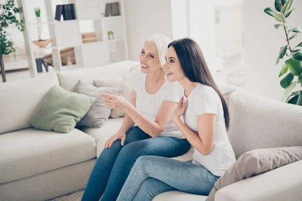 Ritratto di due belle belle belle donne allegre allegre sedute sul divano guardare interessante show televisivo cinema film trascorrere il tempo libero giorno libero in luce bianca casa interna appartamento piatto — Foto Stock