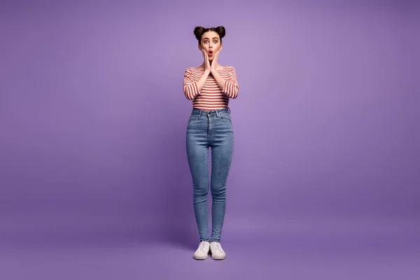 Foto de longitud completa de la señora adolescente bonita dos lindos bollos brazos de buen humor en las mejillas escuchar buenas noticias desgaste blanco rojo casual camisa a rayas jeans zapatos aislados color pastel púrpura fondo — Foto de Stock