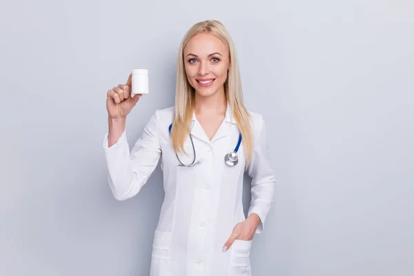 Portret jej ładne atrakcyjne piękne i pewne siebie dziewczyna medyk terapeuta specjalista stetoskop trzymając w ręku nowy lek rozwiązanie witaminy izolowane na szarym pastelowym tle kolor — Zdjęcie stockowe