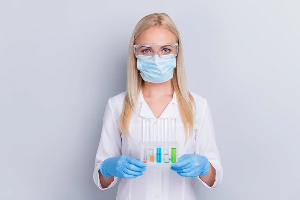 Κοντινό πλάνο πορτρέτο της αυτή ωραία επαγγελματική κορίτσι αναισθησιολόγος επιστήμονας βιολόγος φορώντας γάζα μάσκα κρατώντας στα χέρια λαμπτήρες θεραπεία επιδημία πανδημία απομονωμένη γκρι παστέλ χρώμα φόντο — Φωτογραφία Αρχείου
