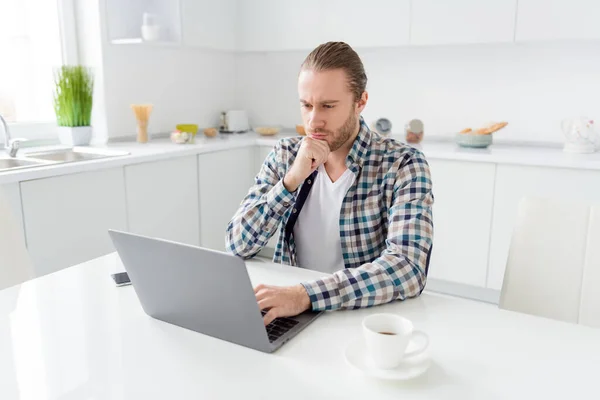 Portrait of focused minded guy sit kitchen table work distance use laptop read colleagues presentation analyze wear good look clothes in house light apartment