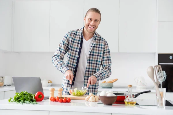 Retrato de chico alegre positivo disfrutar de cocinar fresco plato orgánico fin de semana preparar ensalada mezcla de tomate lechuga col desgaste casual traje a cuadros en la casa de la cocina en interiores — Foto de Stock