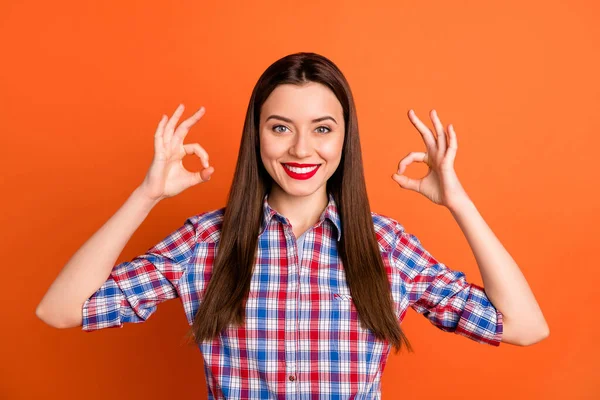 Foto de atractiva dama brillante rojo pomada sonrisa dentada levantar brazos mostrando símbolos okey expresando acuerdo usar camisa a cuadros casual aislado vibrante color naranja fondo — Foto de Stock