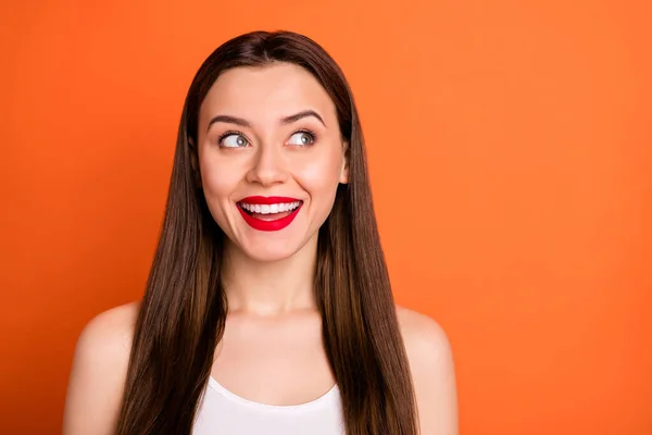 Close-up foto van schattige aantrekkelijke vrolijke dame goed humeur kijken geïnteresseerd kant lege ruimte dragen casual witte tank top geïsoleerde levendige oranje kleur achtergrond — Stockfoto