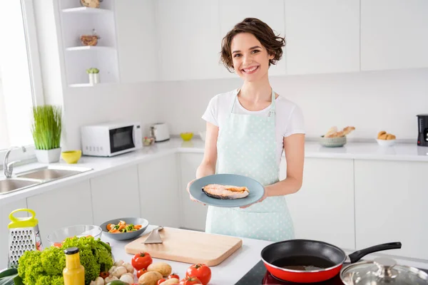 Photo of pretty housewife lady put grilled salmon trout fillet steak flying pan on plate ready roasted condition cook dinner health care breakfast wear apron stand modern kitchen indoors — Stock Photo, Image