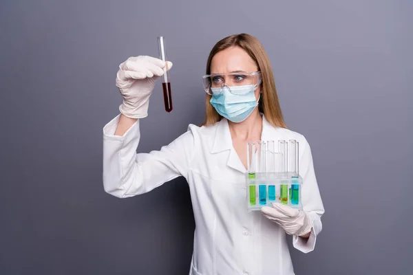 漂亮迷人的有重点金发女孩的画像聪明的医学生物学家手握试管实验分析灰色紫红色背景下的生物分离 — 图库照片