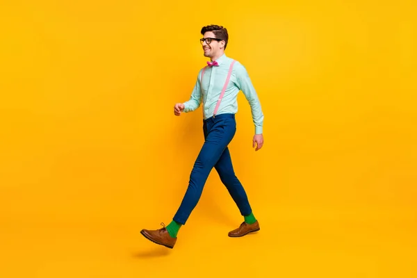 Full length profile photo of cool stylish guy boyfriend walking down street date girlfriend wear specs shirt bow tie suspenders trousers shoes isolated vivid yellow color background — Stock Photo, Image