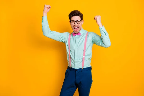 Retrato de homem encantado positivo desfrutar regozijar corona vírus ganhar levantar punhos gritar sim usar boa aparência azul roupa isolada sobre brilho brilhante cor fundo — Fotografia de Stock