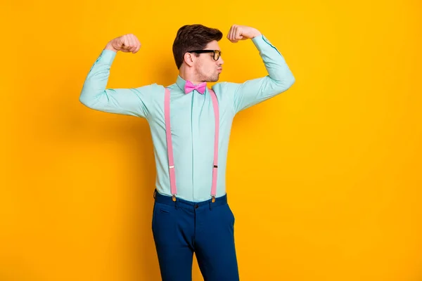 Foto van een knappe coole kerel met twee grote biceps spieren na quarantaine training elke dag nuttige slijtage specs shirt bretels strik broek geïsoleerde gele kleur achtergrond — Stockfoto