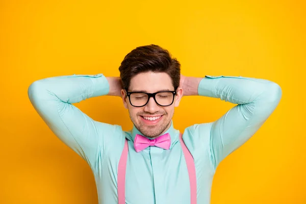 Closeup bilde av stilige klær fyr som stråler smil øyne lukket bak hoderapning øyeblikk bære briller bukseseler sløyfe slips isolert lys gul bakgrunn – stockfoto