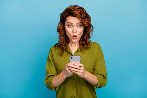 Portret oszołomionej szalonej kobiety używać smartfona wrażenie social media informacje spojrzenie stupor ekran nosić dobry wygląd ubrania odizolowane na tle niebieskiego koloru — Zdjęcie stockowe