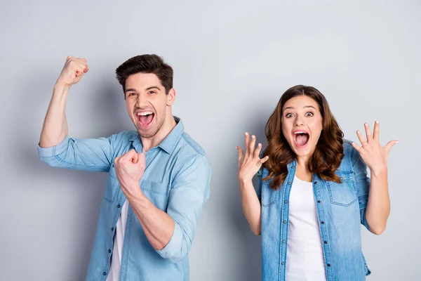 Foto dos personas emocionadas señora funky loco guapo chico escuchar buenas noticias puños manos levantadas ricos ricos ganar lotería desgaste casual denim camisas traje aislado gris color fondo —  Fotos de Stock