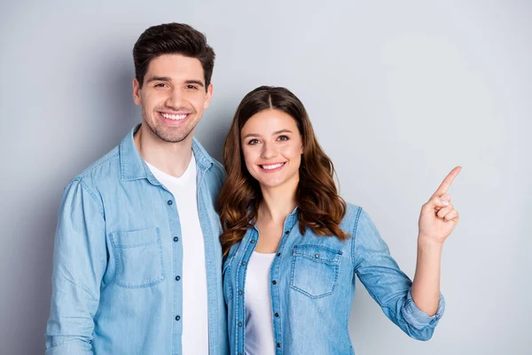 Photo two people attractive lady handsome guy direct finger side empty space ravising cool offer shopping store wear casual denim shirts outfit isolated grey color background — Zdjęcie stockowe