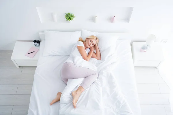 Top above high angle view of her she nice attractive healthy dreamy aged woman lying in bed sleeping in silence spending weekend in modern light white interior room flat apartment