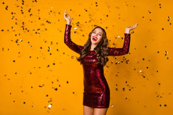 派手な狂気の波状の女性の写真赤明るいポマードお祝いイベントパーティーダンスナイトコンフェッティ落下キャッチキラキラ星摩耗スパンコールバーガンディミニドレス隔離された黄色の色の背景 — ストック写真
