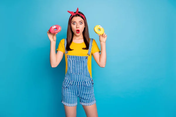 Portrait of her she nice attractive glamorous amazed stunned girl holding in hands two sugary donuts overeat isolated on bright vivid shine vibrant blue green teal turquoise color background — Stock Photo, Image