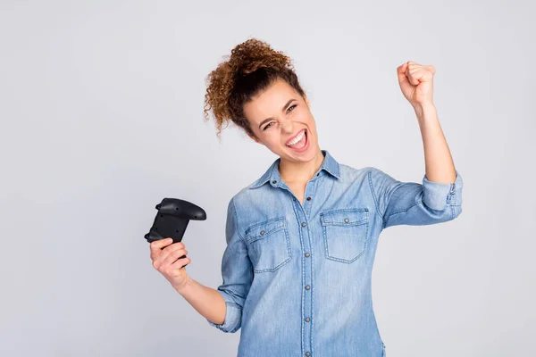 Foto de bela senhora louca segurando joystick viciado jogador bom humor regozijando melhor ganhar levantar punho desgaste casual camisa azul jeans isolado fundo de cor cinza — Fotografia de Stock