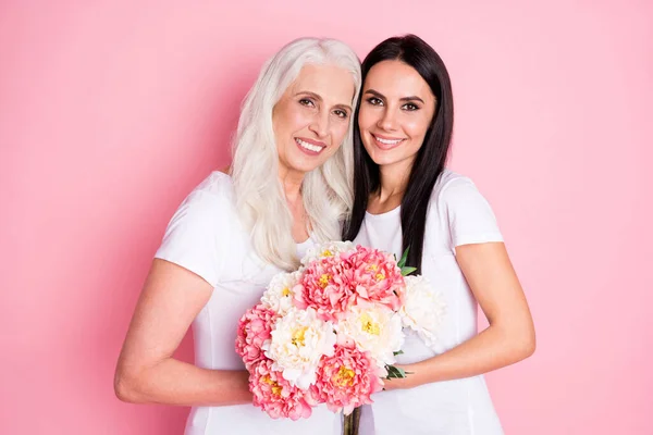 8 번 행진을 기념하기 위해 화려 한 꽃 다발을 들고 있는 밝은 어머니와 어린 딸의 사진 흰색 티셔츠를 입고 있다. — 스톡 사진