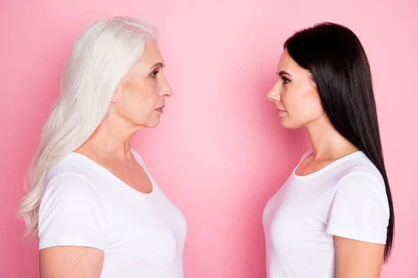 Φωτογραφία προφίλ της αρκετά μεγάλη μητέρα νεαρή κόρη δύο κυρίες στέκεται απέναντι ματιά μάτια δείτε διαφορά ηλικίας σοφία φορούν casual λευκό t-shirts απομονωμένο παστέλ ροζ χρώμα φόντο — Φωτογραφία Αρχείου