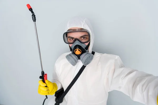 Close up photo of specialist disinfectant clean public places show equipment followers making video selfie blogger wear hazmat protection suit isolated grey color background — Zdjęcie stockowe