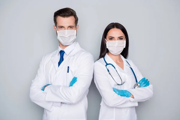 Foto van professionele doc man dame virologie kliniek ervaren artsen armen gevouwen stand back-to-back dragen beschermende gezichtsmaskers handschoenen lab jassen geïsoleerde grijze kleur achtergrond — Stockfoto