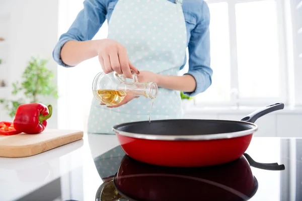 Gewassen foto van mooie huisvrouw houden olijfolie gieten hete koekenpan genieten hobby ochtend koken lekker diner familie stand helder licht keuken binnen casual kleding — Stockfoto