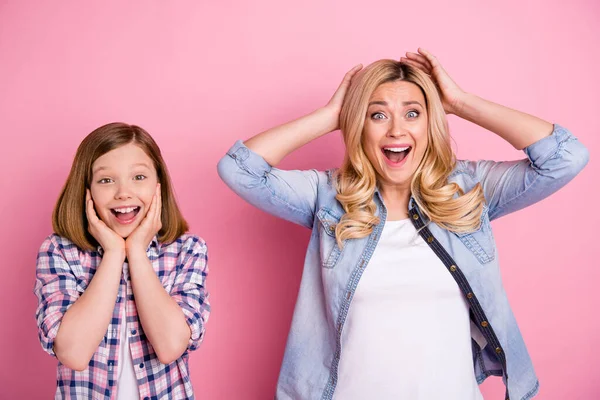 Surpreso positivo loira cabelo mulher criança mãe filha ouvir incrível família pechincha desconto toque cabeça mãos gritar desgaste xadrez jeans camisa isolado pastel cor fundo — Fotografia de Stock