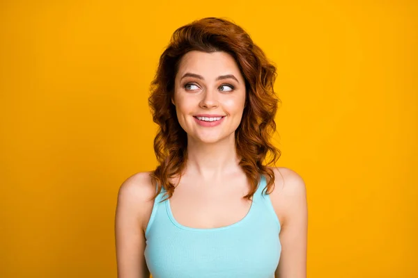 Foto de cerca de la señora foxy bastante rizado persona alegre buen humor dientes blancos sonrisa mirada lado interesado espacio vacío desgaste azulado casual singlet aislado vibrante color amarillo fondo — Foto de Stock