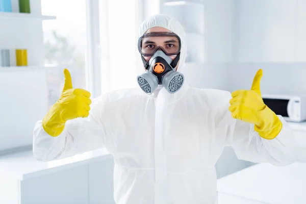 Portrait of successful worker cleaner man in glasses gloves show thumb up symbol approve decontamination covid-19 flu infection procedure wear goggles latex gloves in house kitchen indoors